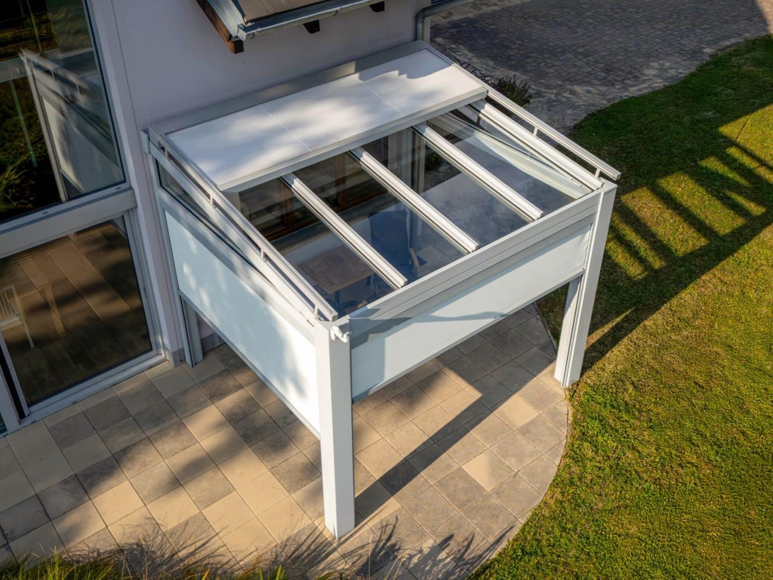 Pergola LAMARK se skleněnou střechou přisazená ke stěně | Stříbrná hliníková barva | Screenové rolety | Větrné čidlo | LED osvětlení