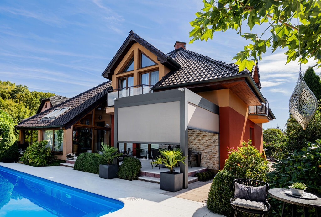 Bioklimatická pergola LAMARK přisazená ke stěně | Plzeň | Boční stínění - screenové rolety | Šedá antracitová barva | Dešťové čidlo | Větrné čidlo