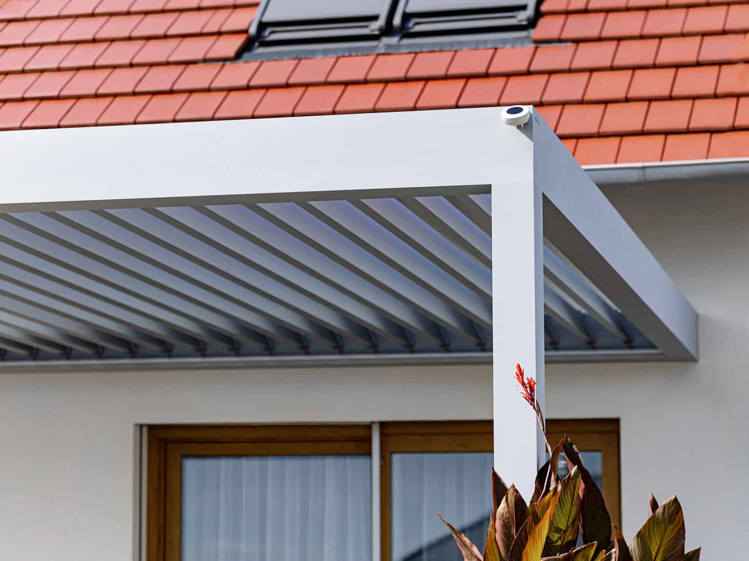 Detail bioklimatické pergoly LAMARK přisazené ke stěně | Městec Králové | Stříbrná hliníková barva | Dešťové čidlo