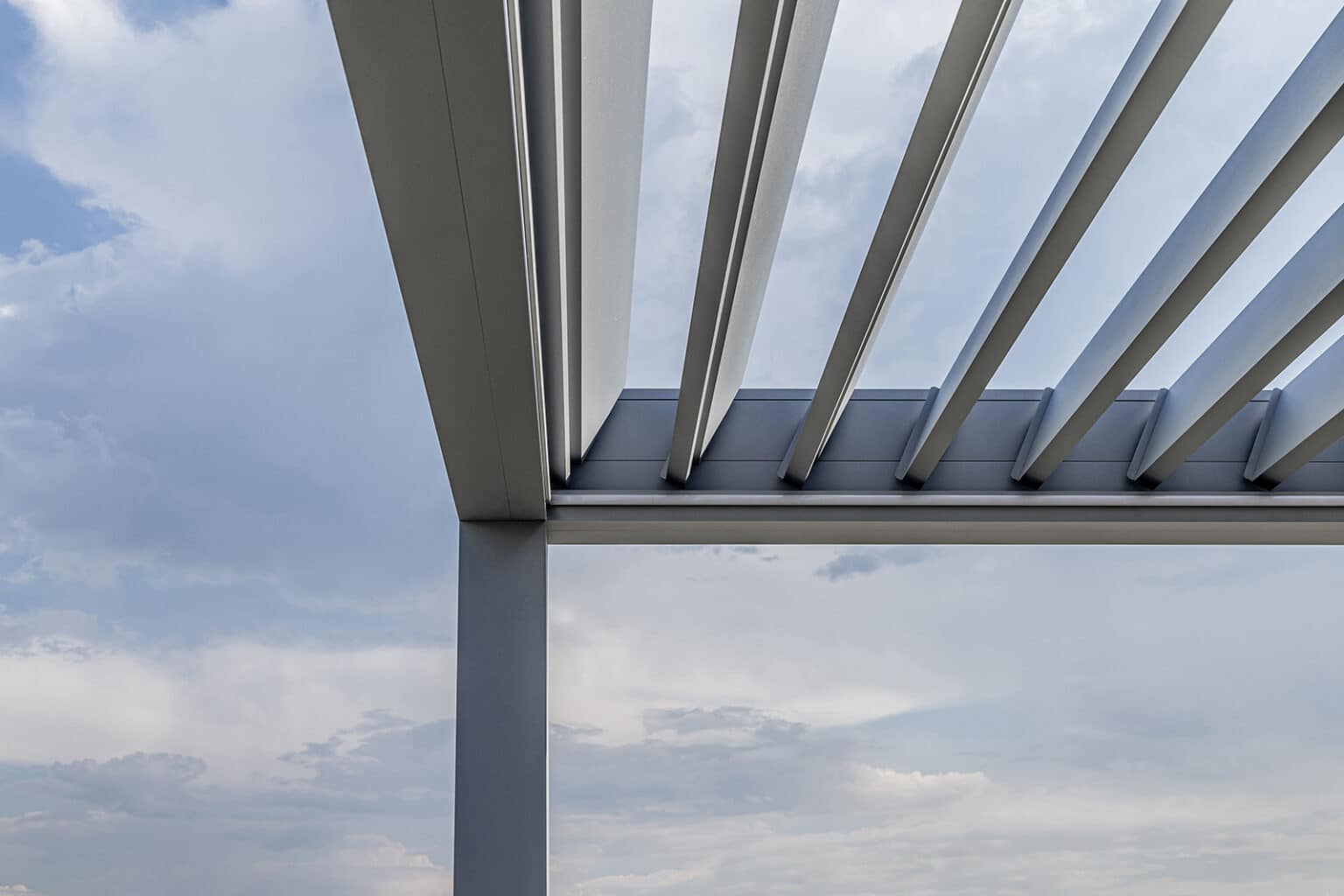 Detail bioklimatické pergoly LAMARK přisazené ke stěně | Městec Králové | Stříbrná hliníková barva