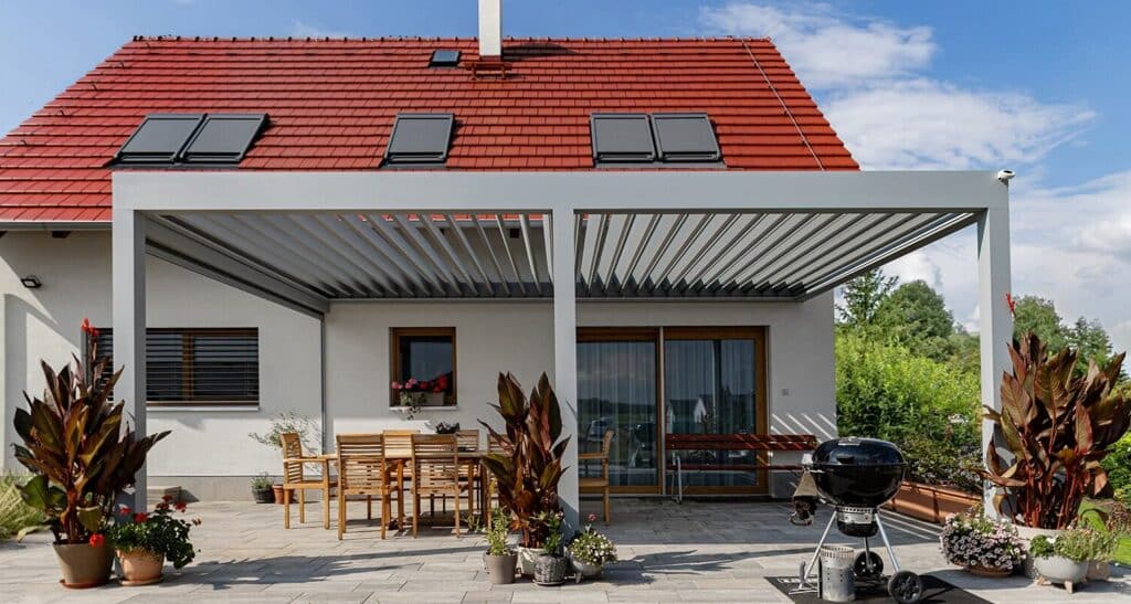 Bioklimatická pergola LAMARK přisazená ke stěně | Městec Králové | Boční stínění - screenová roleta | Stříbrná hliníková barva | Dešťové čidlo | Ovládání