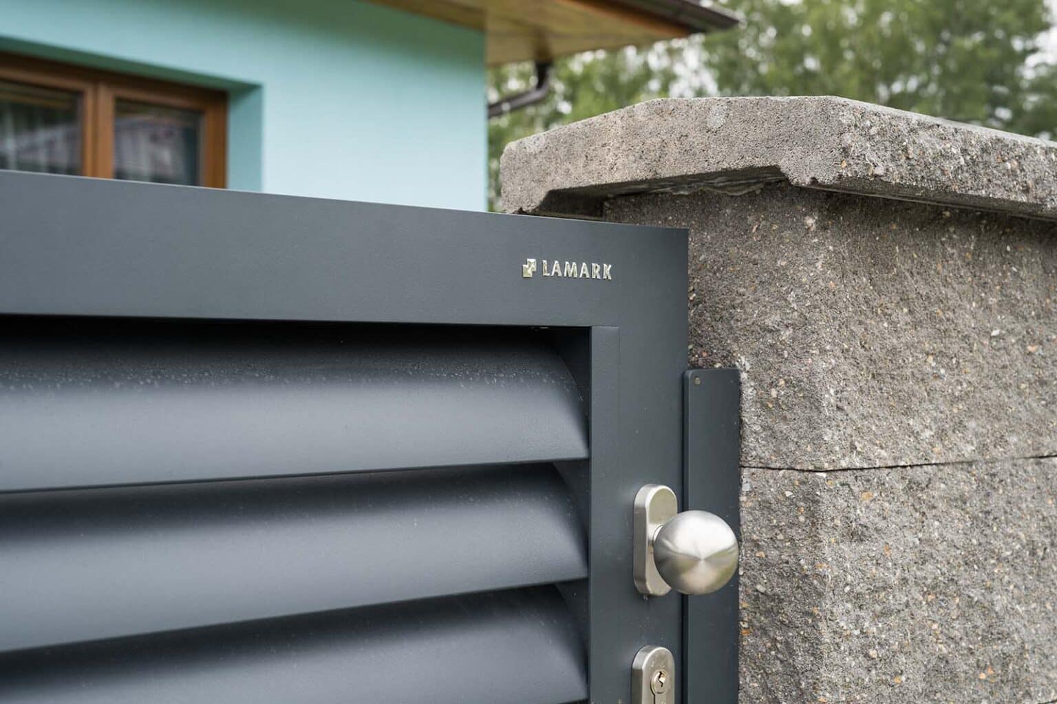 Detail kliky a loga LAMARK | Hliníková jednokřídlá branka LAMARK | Motiv Viana | Šedá antracitová barva | Sloupky z betonových bloků