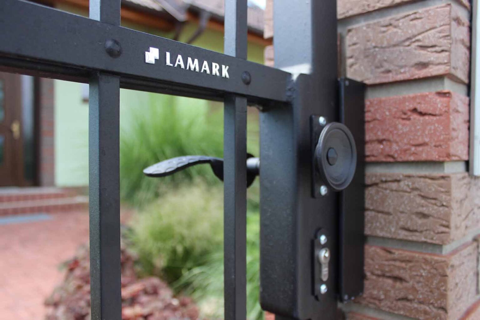 Detail na kliku a logo LAMARK | Kovaná jednokřídlá branka LAMARK | Motiv Lincoln | Černá kovářská barva | Hladké provedení | S nýty