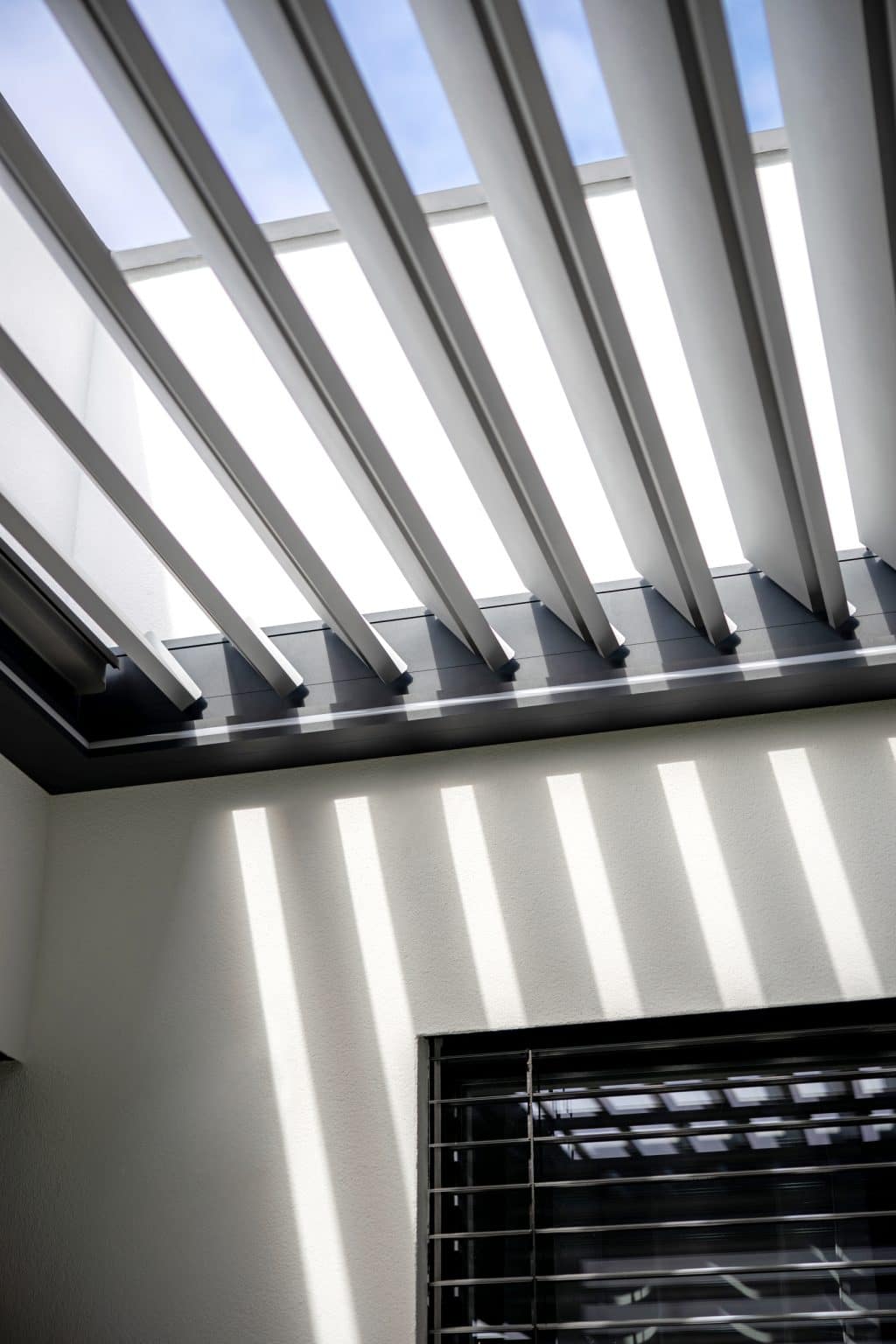 Detail lamel bioklimatické pergoly LAMARK přisazené ke stěně | Kuřim | Boční stínění - screenové rolety | Šedá antracitová barva