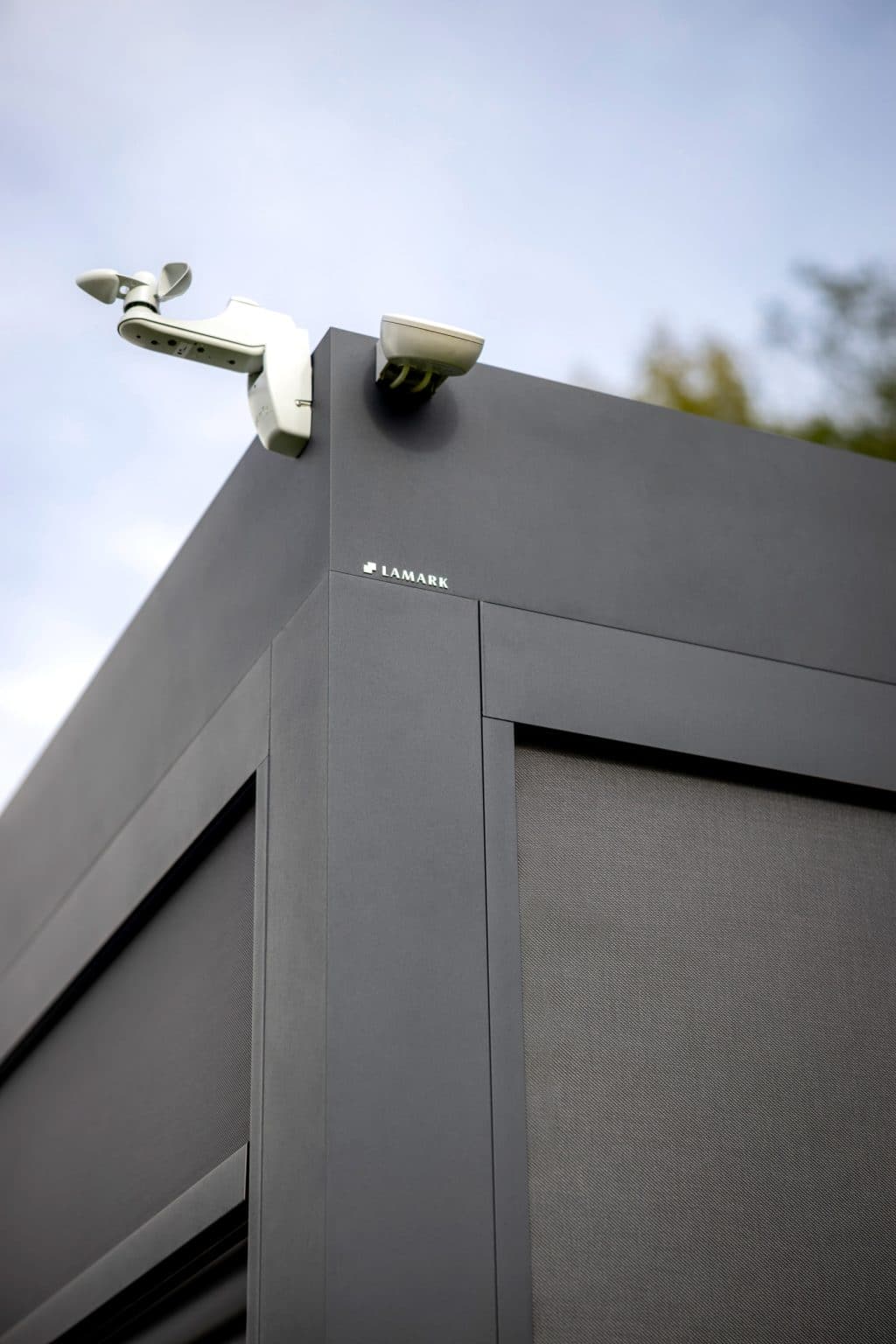 Detail dešťového a větrného čidla a loga LAMARK | Bioklimatická pergola LAMARK přisazená ke stěně | Kuřim | Boční stínění - screenové rolety | Šedá antracitová barva