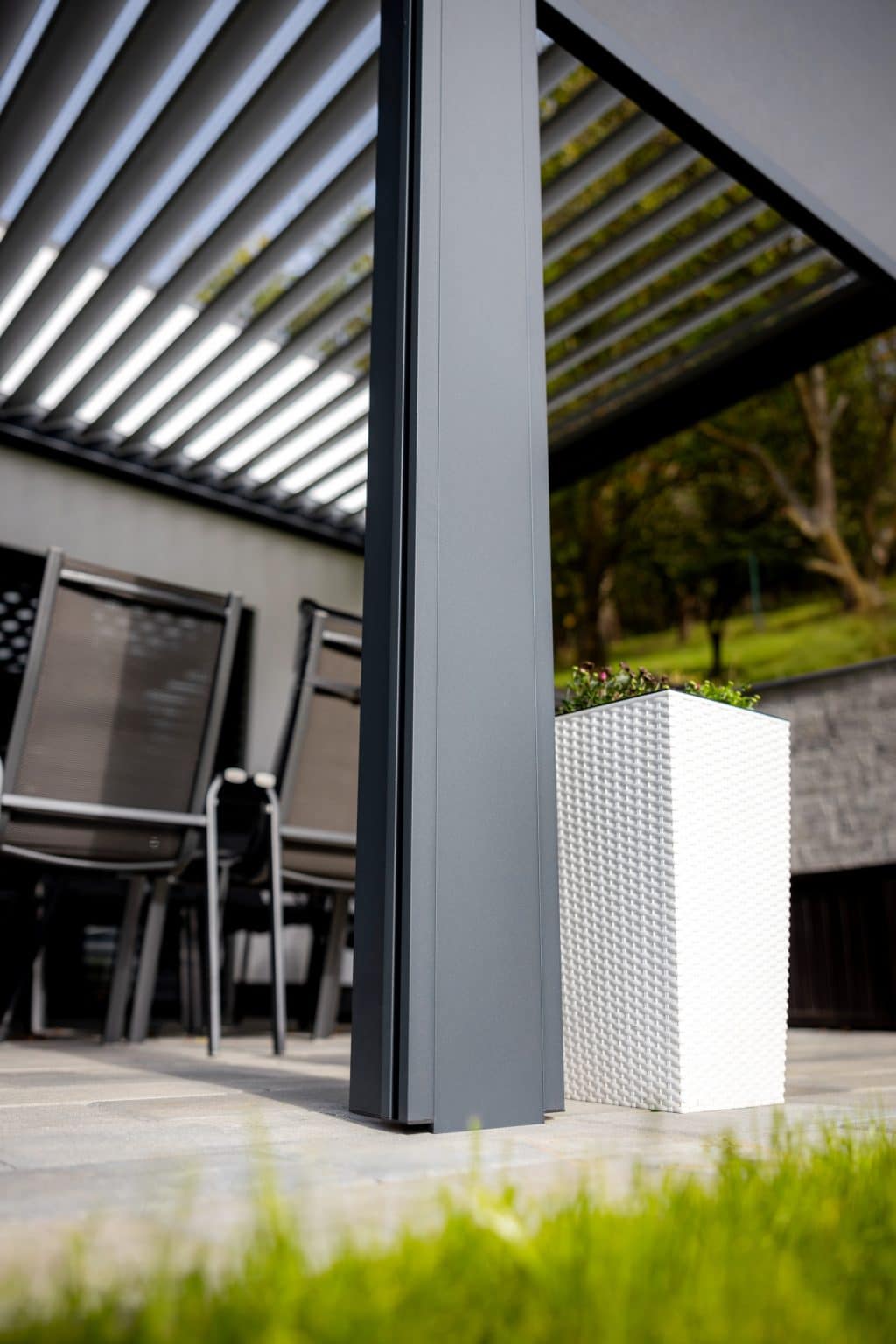 Detail sloupu bioklimatické pergoly LAMARK přisazené ke stěně | Kuřim | Boční stínění - screenové rolety | Šedá antracitová barva | Dešťové čidlo | Větrné čidlo | Ovládání