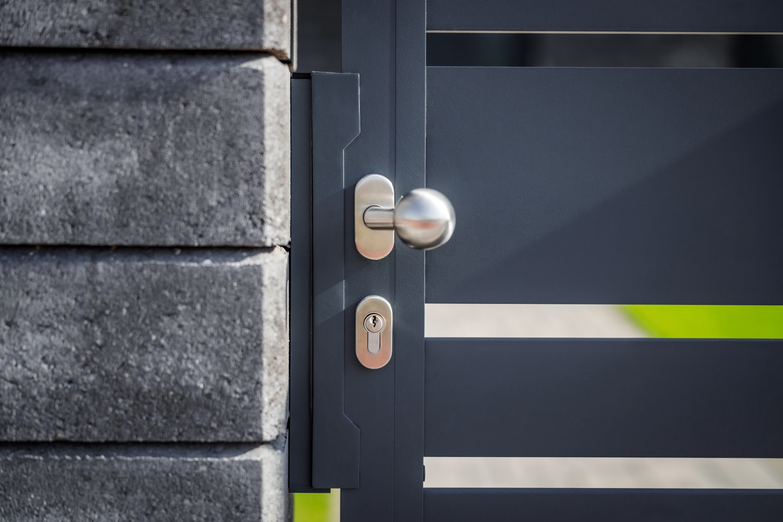 Detail kliky hliníkové branky LAMARK | Motiv Lobon | Šedá antracitová barva | Betonové sloupky