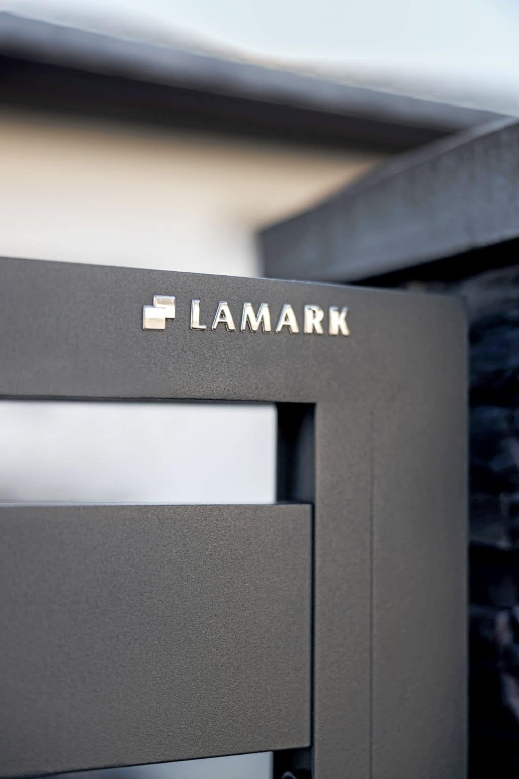 Detail loga LAMARK na hliníkovém plotě | Motiv Lobon | Šedá antracitová barva | Zděné sloupky