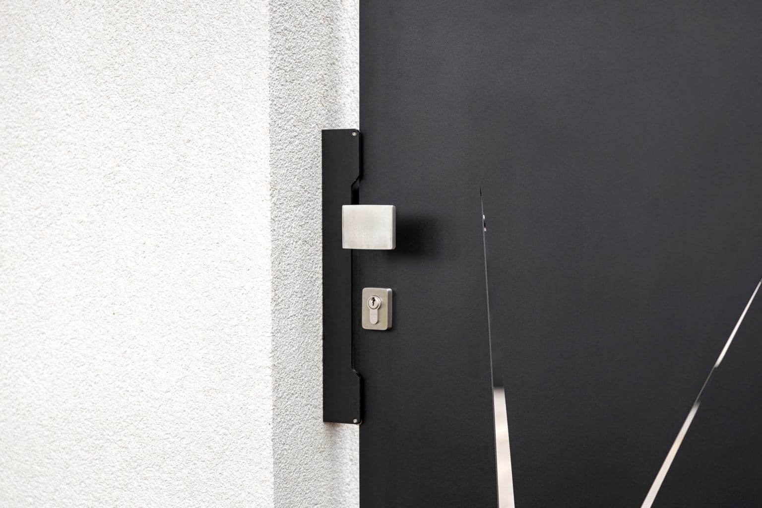 Detail kliky na deskovém plotě LAMARK | Motiv Sora | Černá kovářská barva | Zděné sloupky