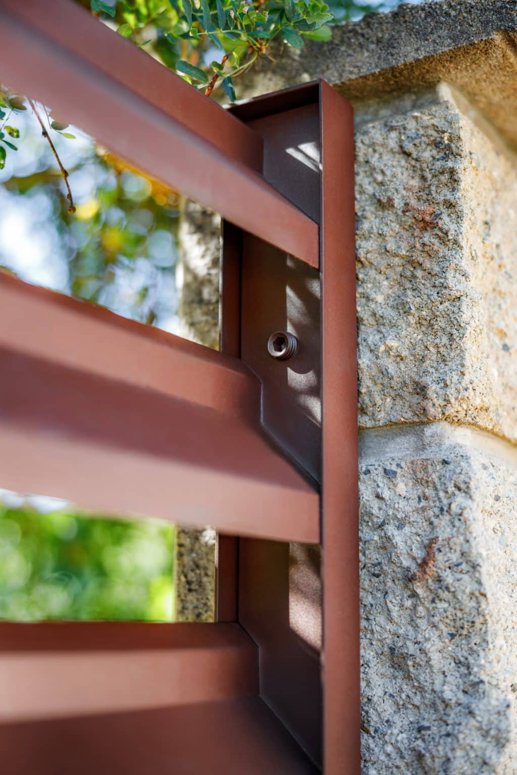 Detail uchycení hliníkového plotu LAMARK | Motiv Lugo Air | Hnědá čokoládová barva | Betonové sloupky