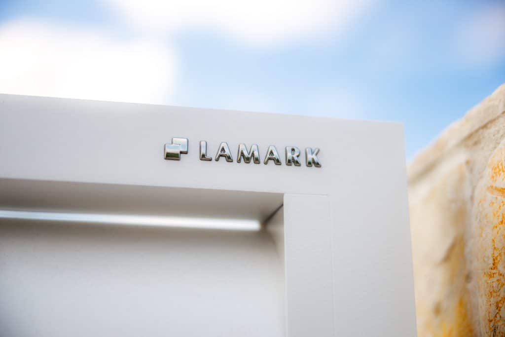 Detail loga LAMARK na hliníkové brance | Motiv Viana Air | Bílá polární barva | Zděné sloupky