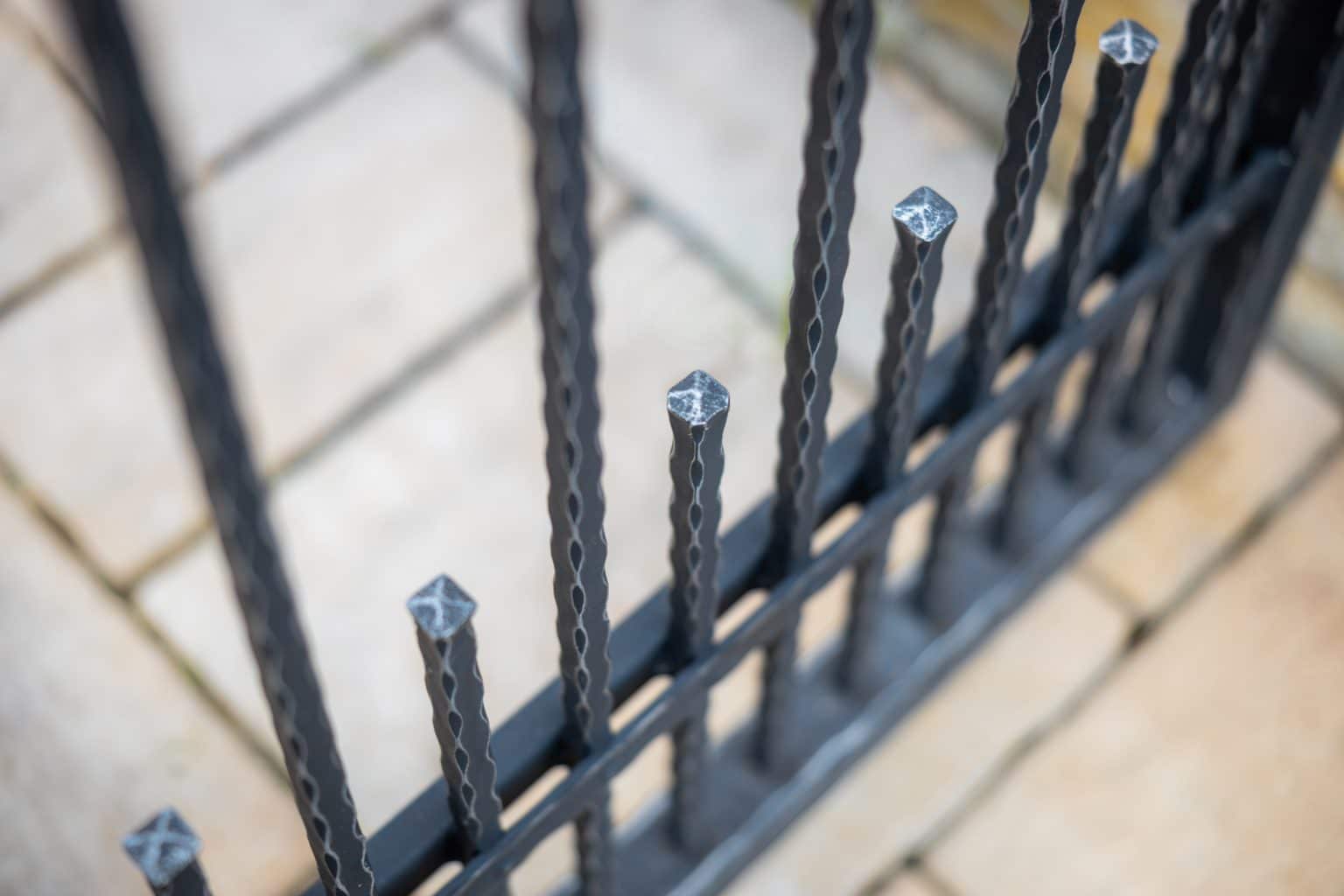 Detail motivu Verona na kovaném plotě LAMARK | Černá kovářská barva | Stříbrná patina | Svařované s nýty | Oklepávané provedení | Okované konce