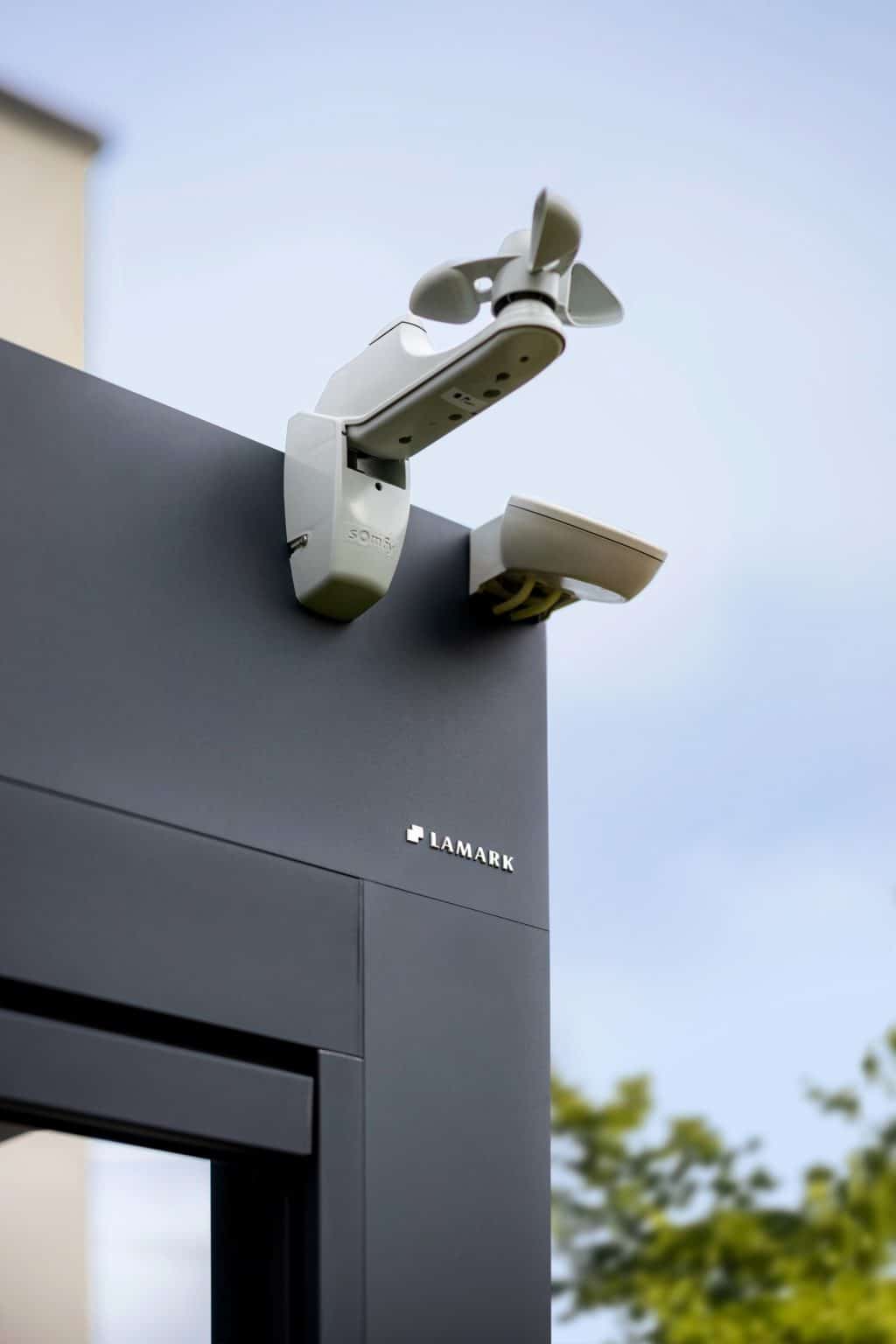 Detail dešťového a větrného čidla | Bioklimatická pergola LAMARK přisazená ke stěně | Chotěboř | Boční stínění - screenové rolety | Černá kovářská barva | Ovládání | LED osvětlení