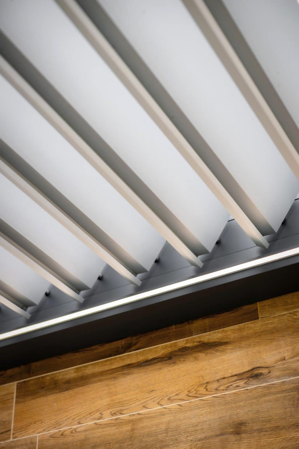 Detail lamel bioklimatické pergoly LAMARK přisazené ke stěně | Chotěboř | Boční stínění - screenové rolety | Černá kovářská barva | LED osvětlení