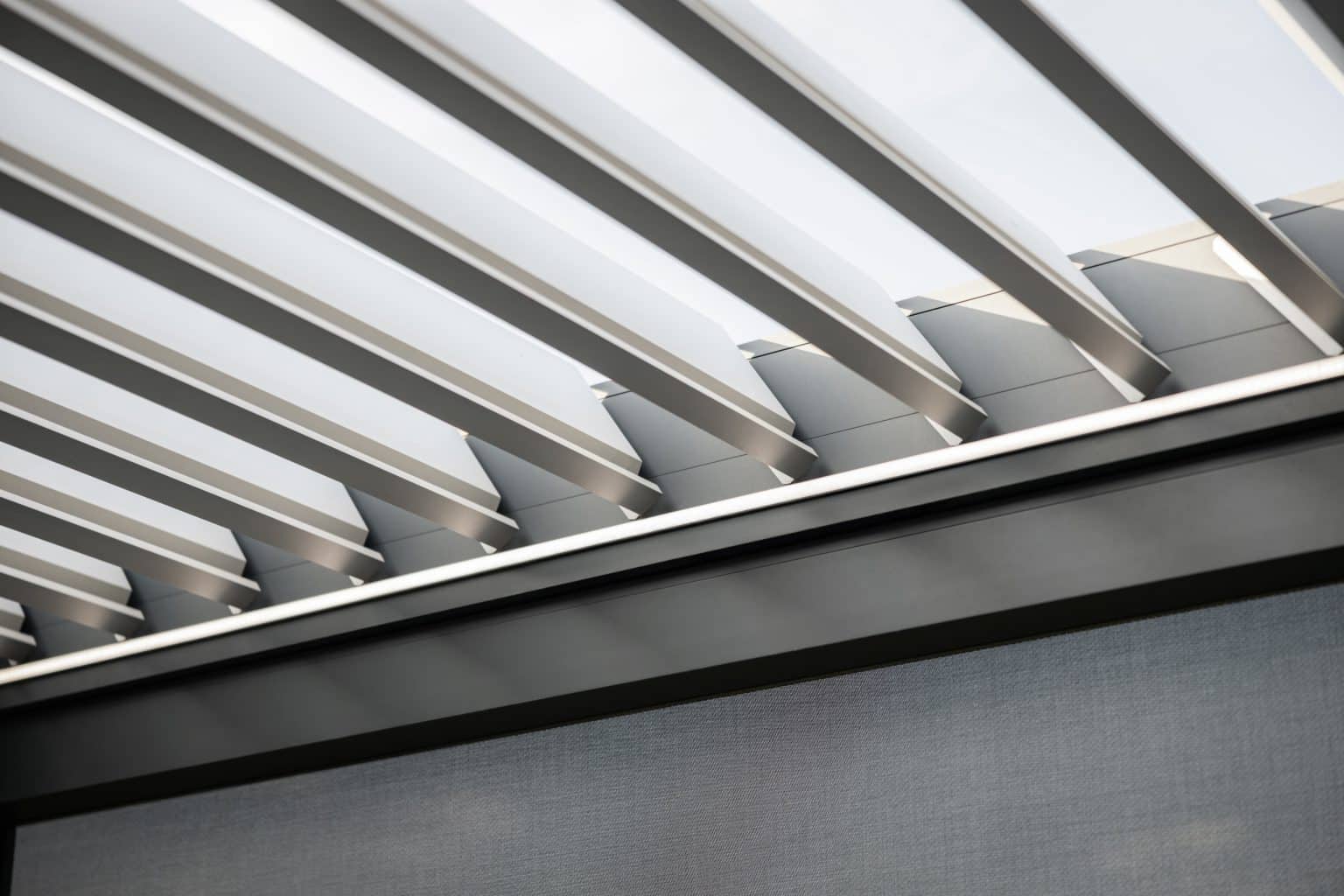 Detail lamel bioklimatické pergoly LAMARK přisazené ke stěně | Staré Nechanice | Boční stínění - screenové rolety | Šedá antracitová barva | LED osvětlení