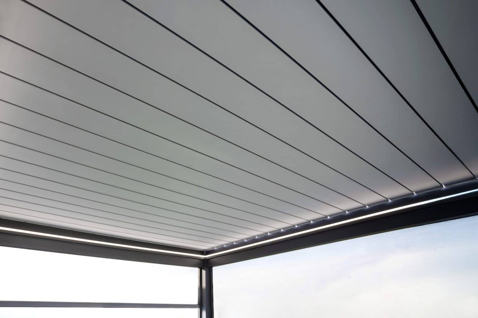 Detail zavřených lamel bioklimatické pergoly LAMARK přisazené ke stěně | Staré Nechanice | Boční stínění - screenové rolety | Šedá antracitová barva | LED osvětlení