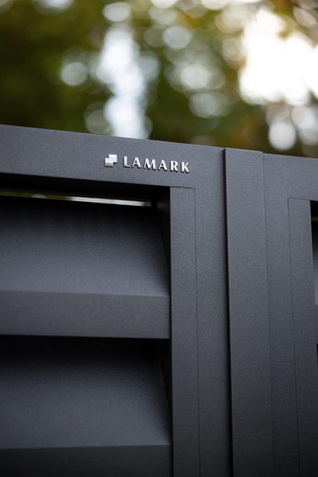 Detail loga LAMARK na hliníkové brance | Motiv Alicante | Šedá antracitová barva | Zděné sloupky a hliníkové sloupky LAMARK