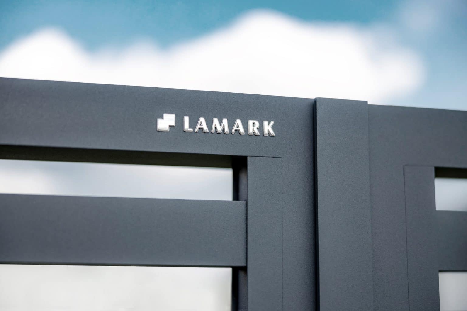 Detail loga LAMARK na hliníkovém plotě | Motiv Avila | Šedá antracitová barva | Zděné sloupky