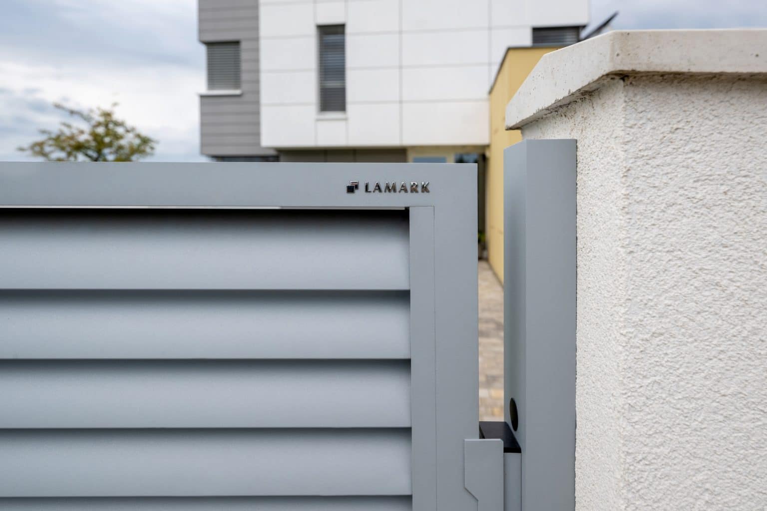 Detail loga LAMARK na hliníkové brance | Motiv Viana | Stříbrná hliníková barva | Zděné sloupky