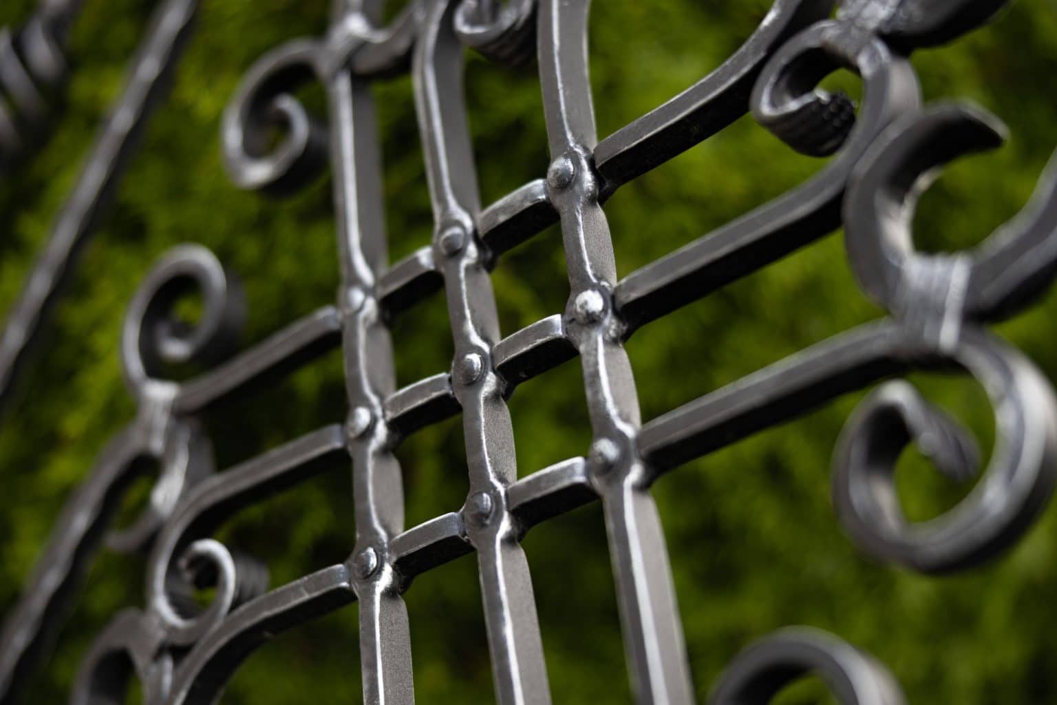 Detail dekoru Nice | Kovaný plot LAMARK | Motiv Bangkok | Černá kovářská barva | Stříbrná patina | Svařované s nýty | Oklepávané provedení | Okované konce