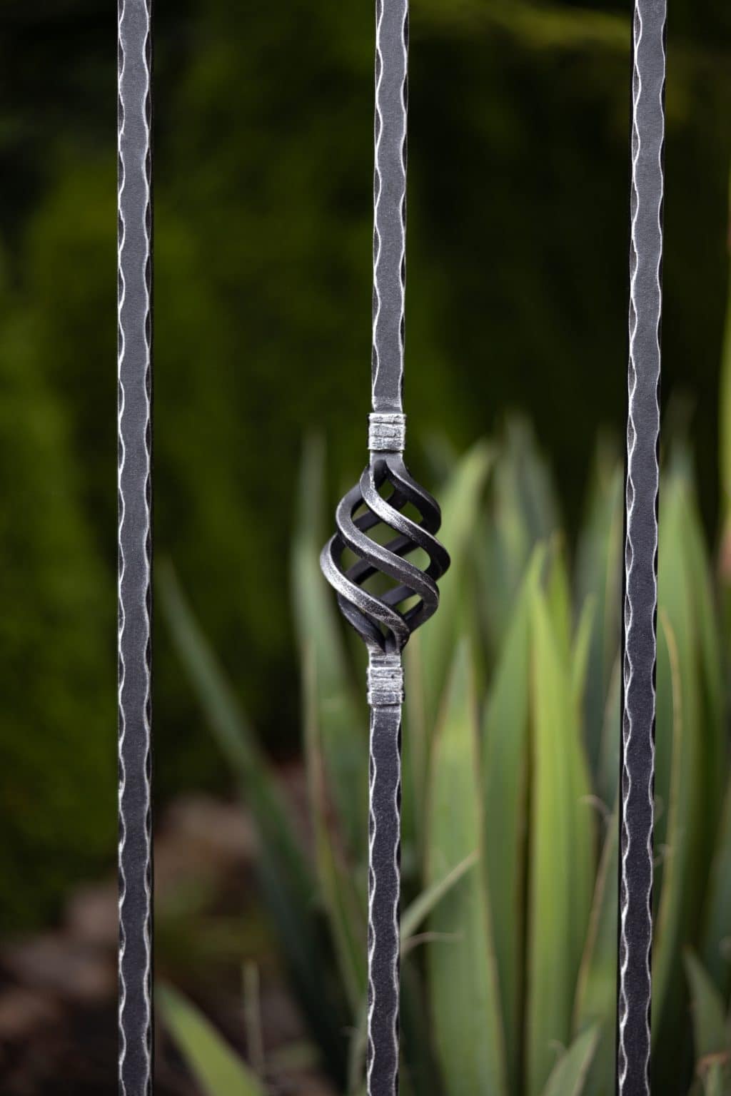 Detail dekoru Nice | Kovaný plot LAMARK | Motiv Bangkok | Černá kovářská barva | Stříbrná patina | Svařované s nýty | Oklepávané provedení | Okované konce