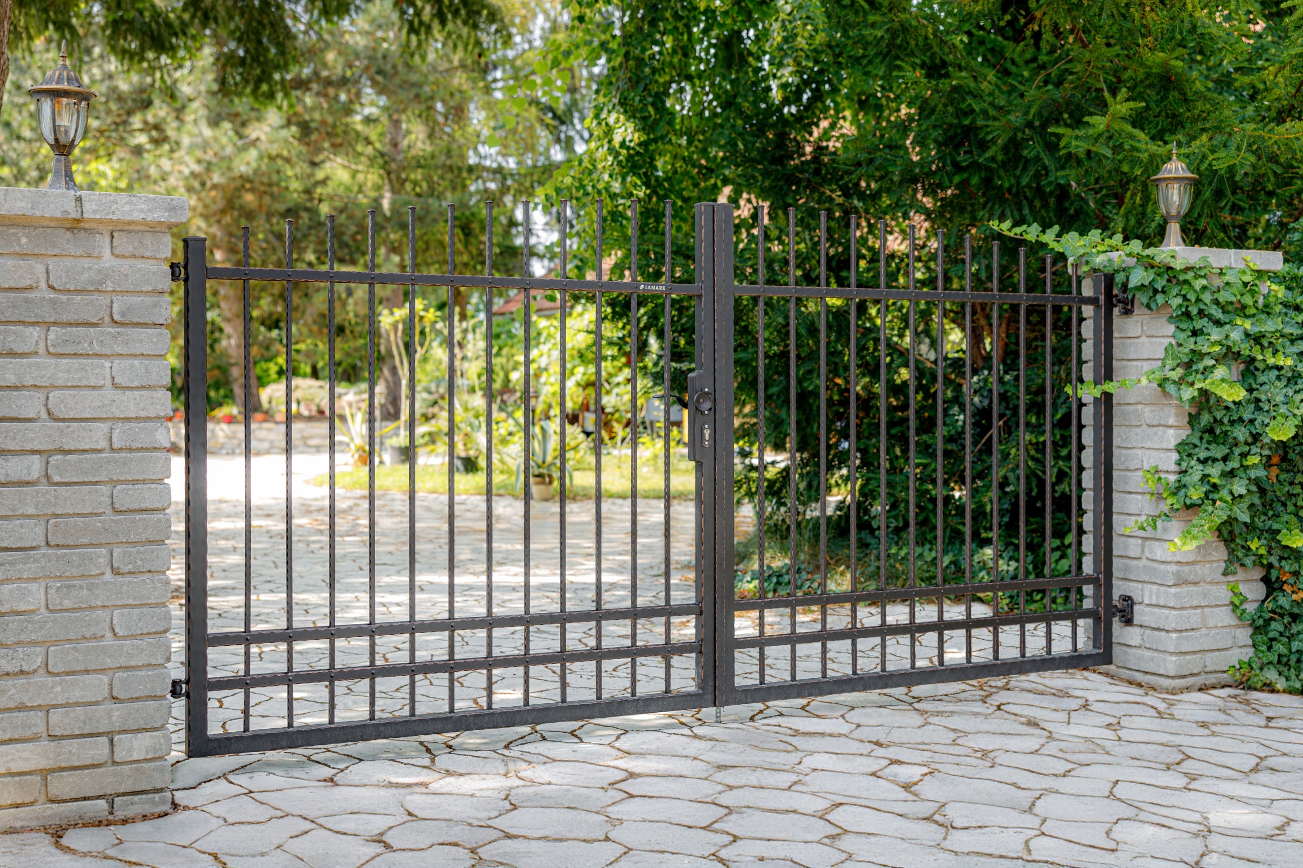 Kovaná otočná brána dvoukřídlá LAMARK s ručním otevíráním | Motiv Detroit | Černá kovářská barva | Měděná patina | Svařované s nýty | Oklepávané provedení | Okované konce | Zděné sloupky