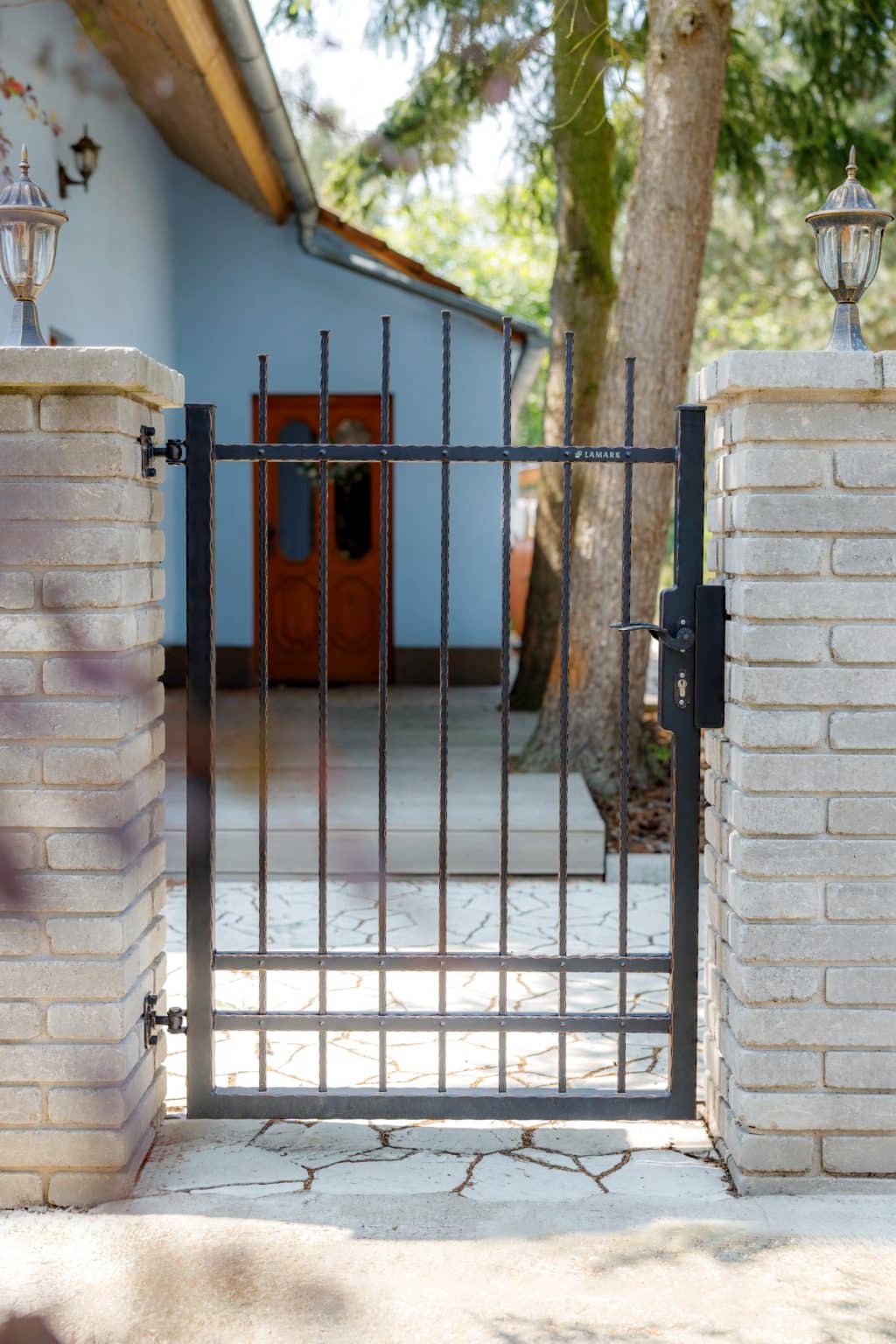 Kovaná jednokřídlá branka LAMARK | Motiv Detroit | Černá kovářská barva | Měděná patina | Svařované s nýty | Oklepávané provedení | Okované konce | Zděné sloupky