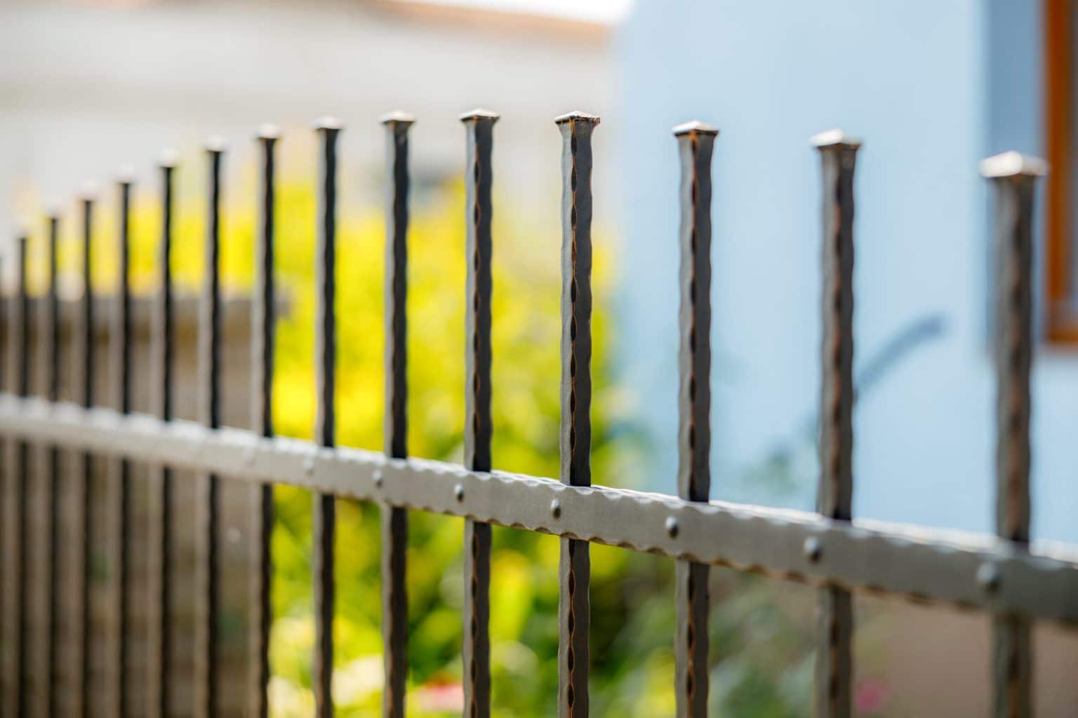 Detail kovaného plotu LAMARK | Motiv Detroit | Černá kovářská barva | Měděná patina | Svařované s nýty | Oklepávané provedení | Okované konce | Zděné sloupky