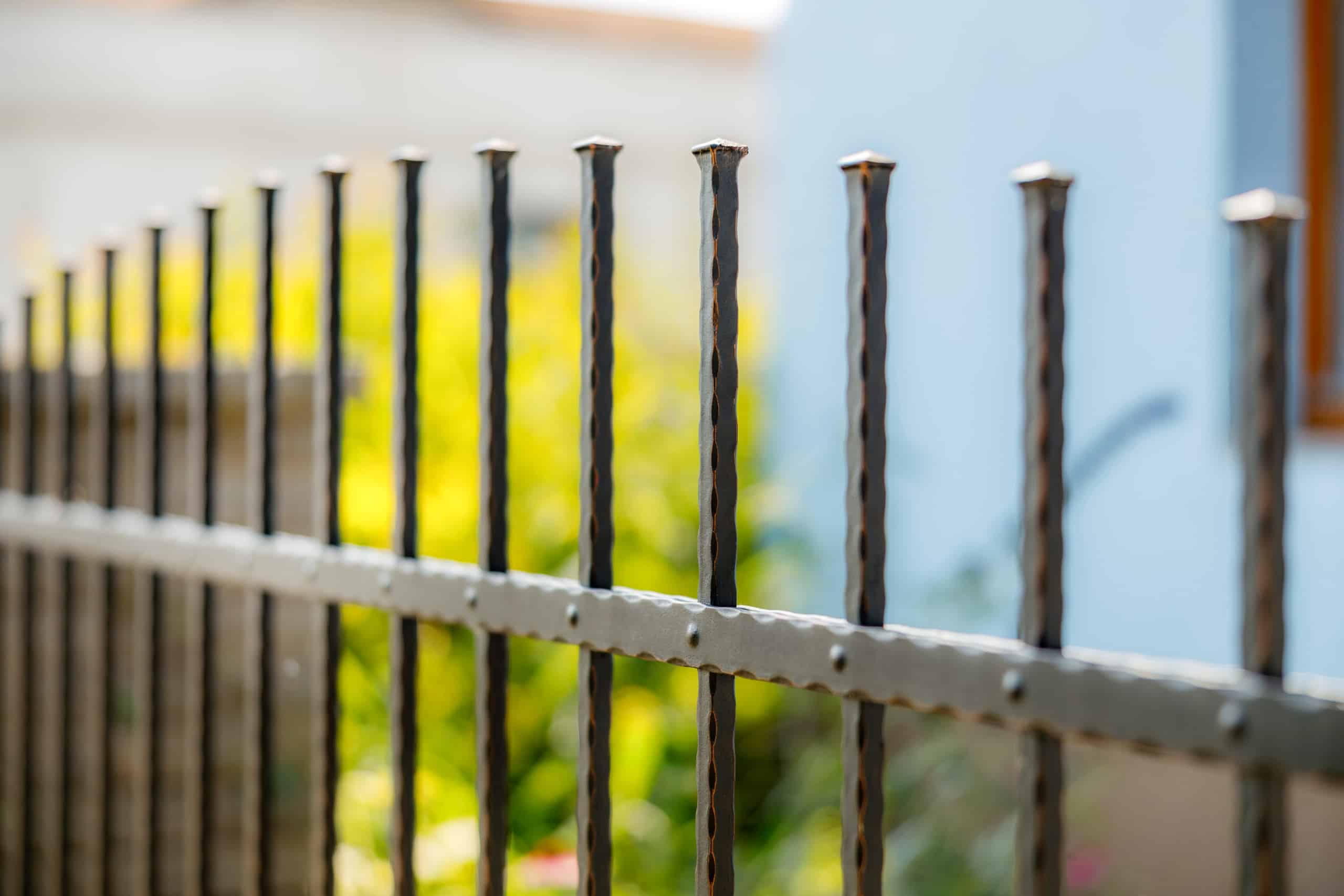 Detail kovaného plotu LAMARK | Motiv Detroit | Černá kovářská barva | Měděná patina | Svařované s nýty | Oklepávané provedení | Okované konce | Zděné sloupky