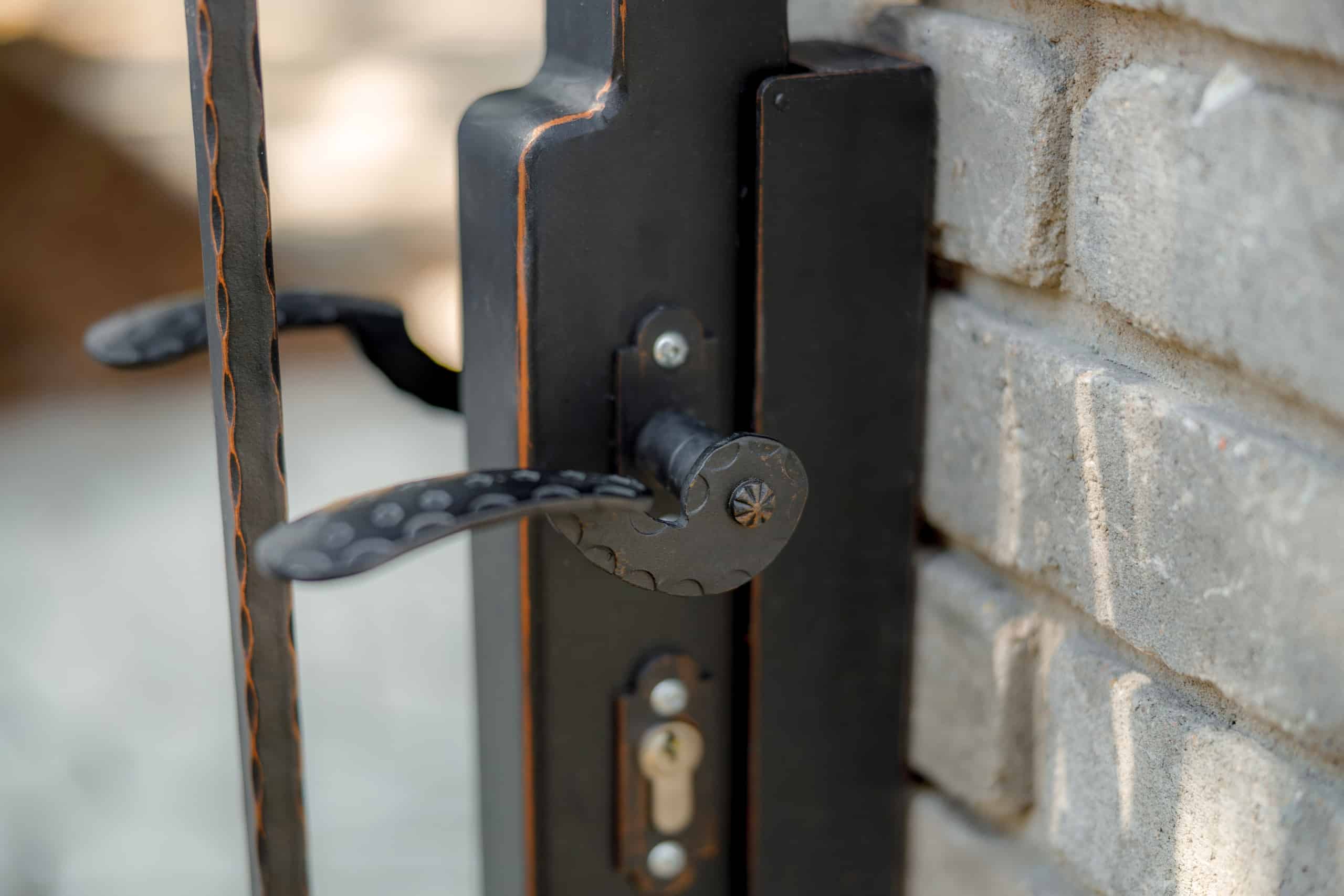 Detail kliky na kované brance LAMARK | Motiv Detroit | Černá kovářská barva | Měděná patina | Svařované s nýty | Oklepávané provedení | Okované konce | Zděné sloupky