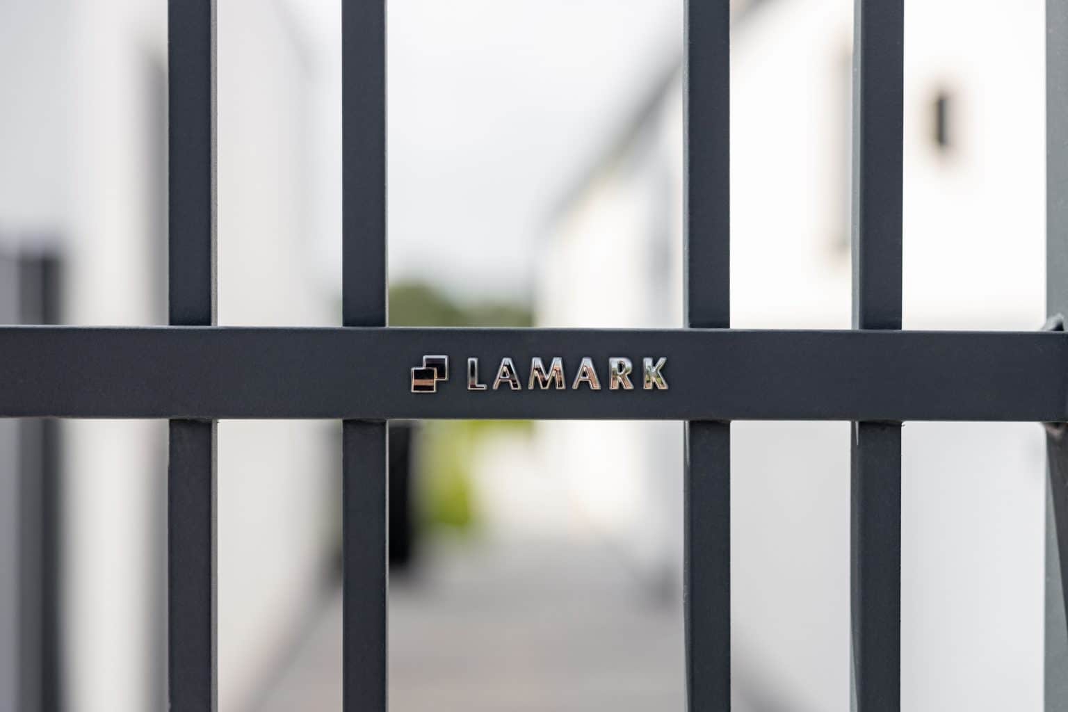 Detail loga LAMARK na kované brance | Motiv Pretoria | Šedá antracitová barva | Svařované bez nýtů | Hladké provedení | Okované konce