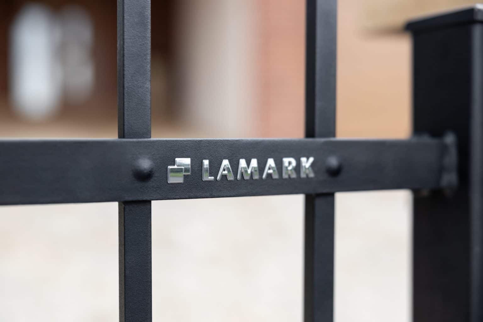 Detail loga LAMARK na kované brance | Motiv Tokio | Černá kovářská barva | Svařované s nýty | Hladké provedení | Okované konce