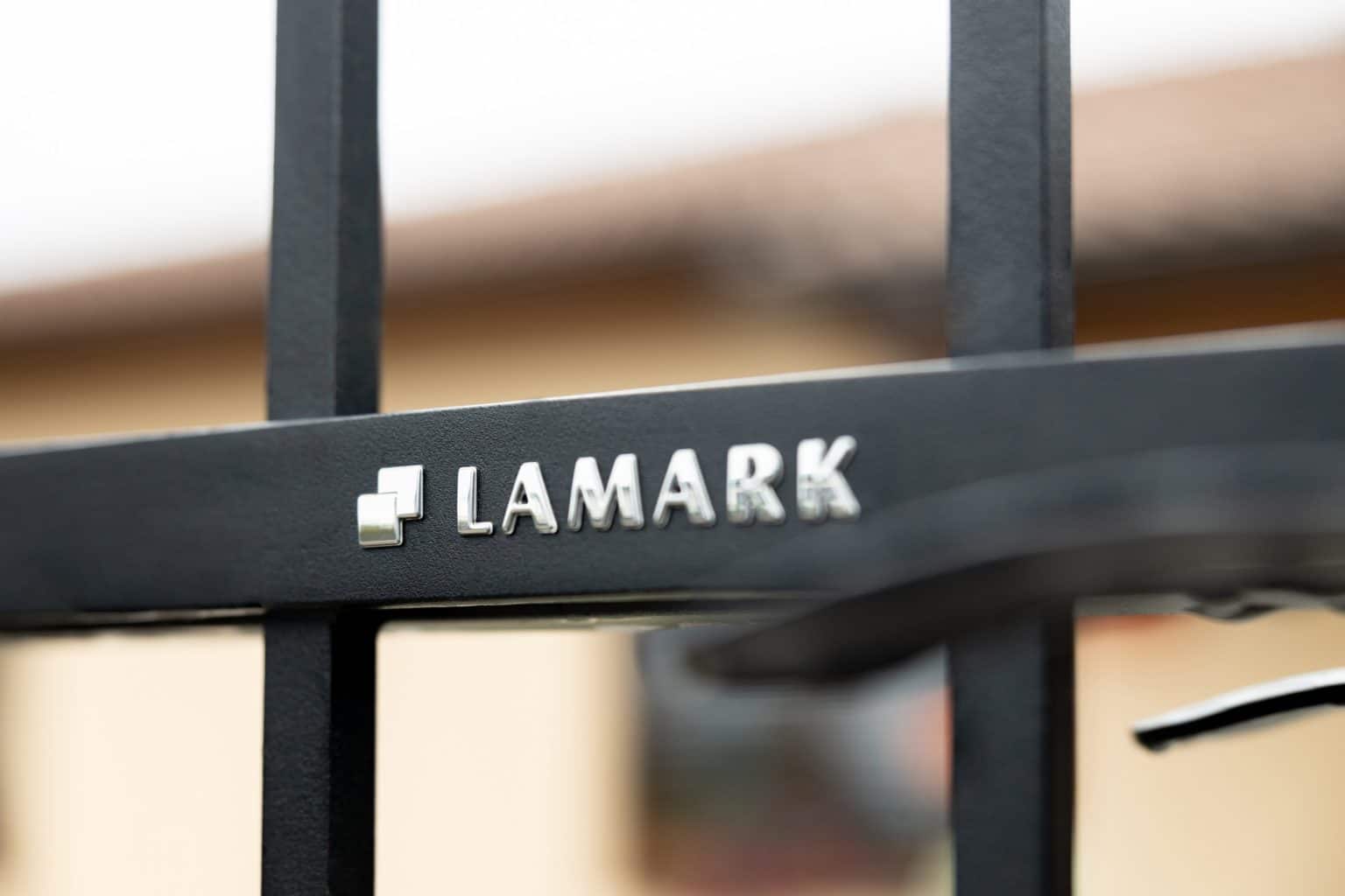 Detail loga LAMARK na kované brance | Motiv Verona | Černá kovářská barva | Svařované bez nýtů | Hladké provedení | Rovné konce