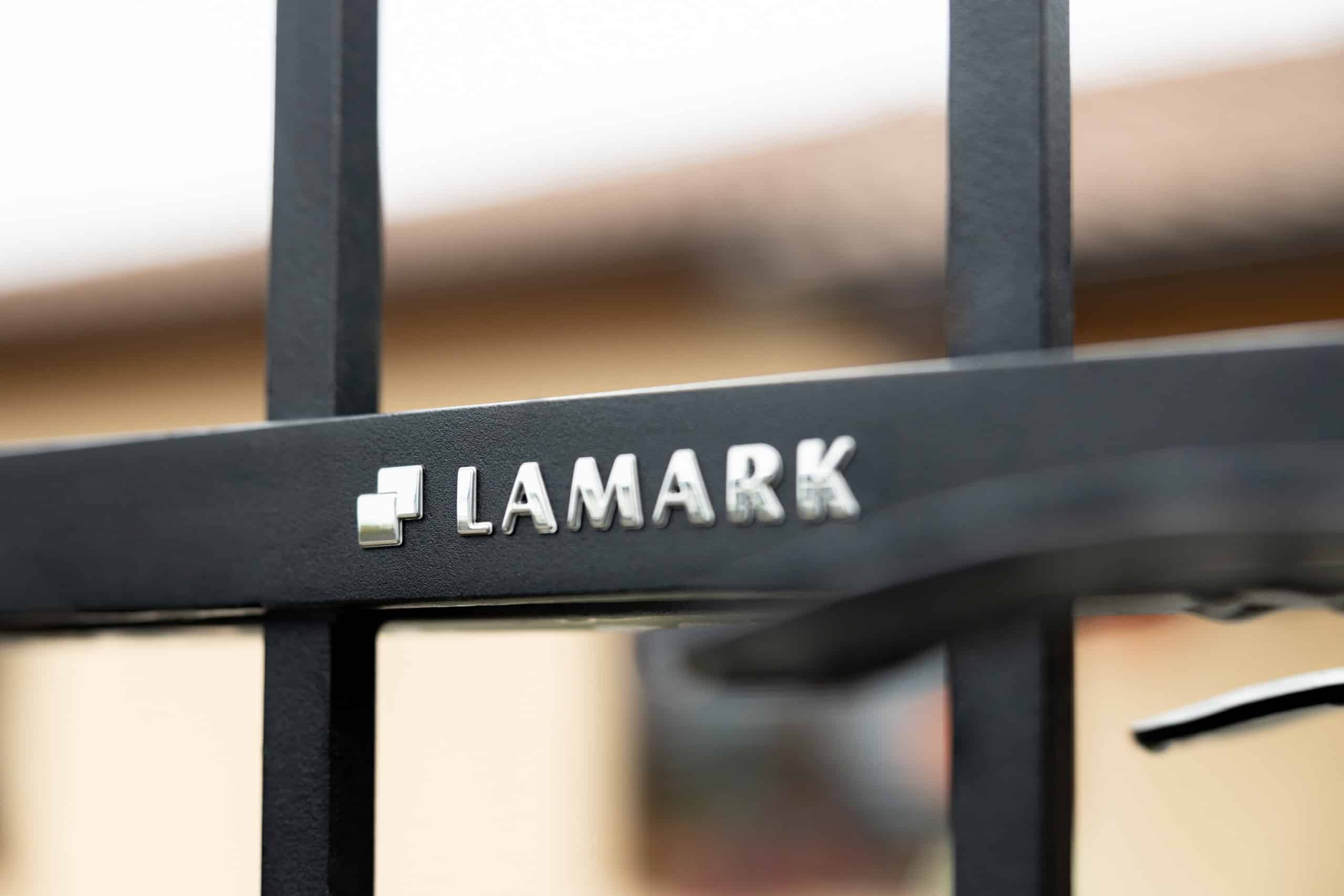 Detail loga LAMARK na kované brance | Motiv Verona | Černá kovářská barva | Svařované bez nýtů | Hladké provedení | Rovné konce