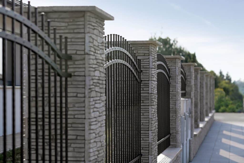 Kovaný plot LAMARK | Motiv Havana | Černá kovářská barva | Měděná patina | Svařované s nýty | Oklepávané provedení | Okované konce | Zděné sloupky