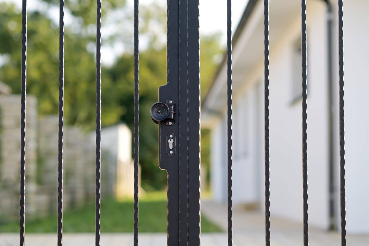 Detail kliky na kované bráně LAMARK | Motiv Havana | Černá kovářská barva | Měděná patina | Svařované s nýty | Oklepávané provedení | Okované konce | Zděné sloupky