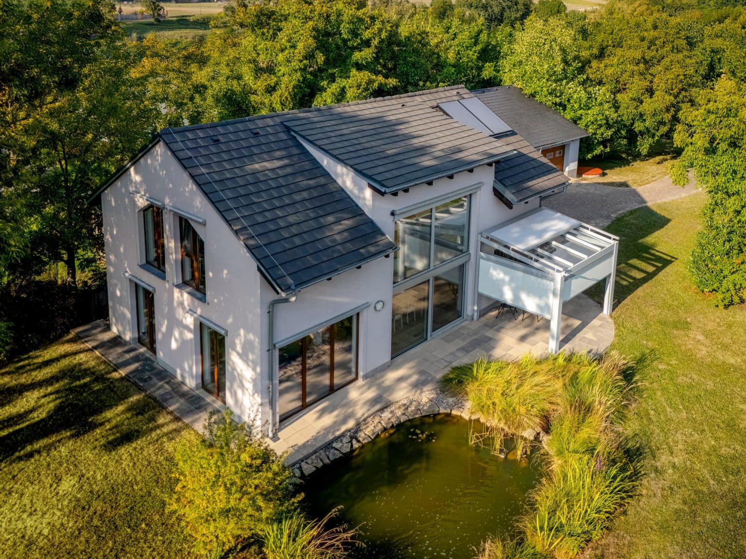 Pergola LAMARK se skleněnou střechou přisazená ke stěně | Stříbrná hliníková barva | Screenové rolety | Větrné čidlo | LED osvětlení