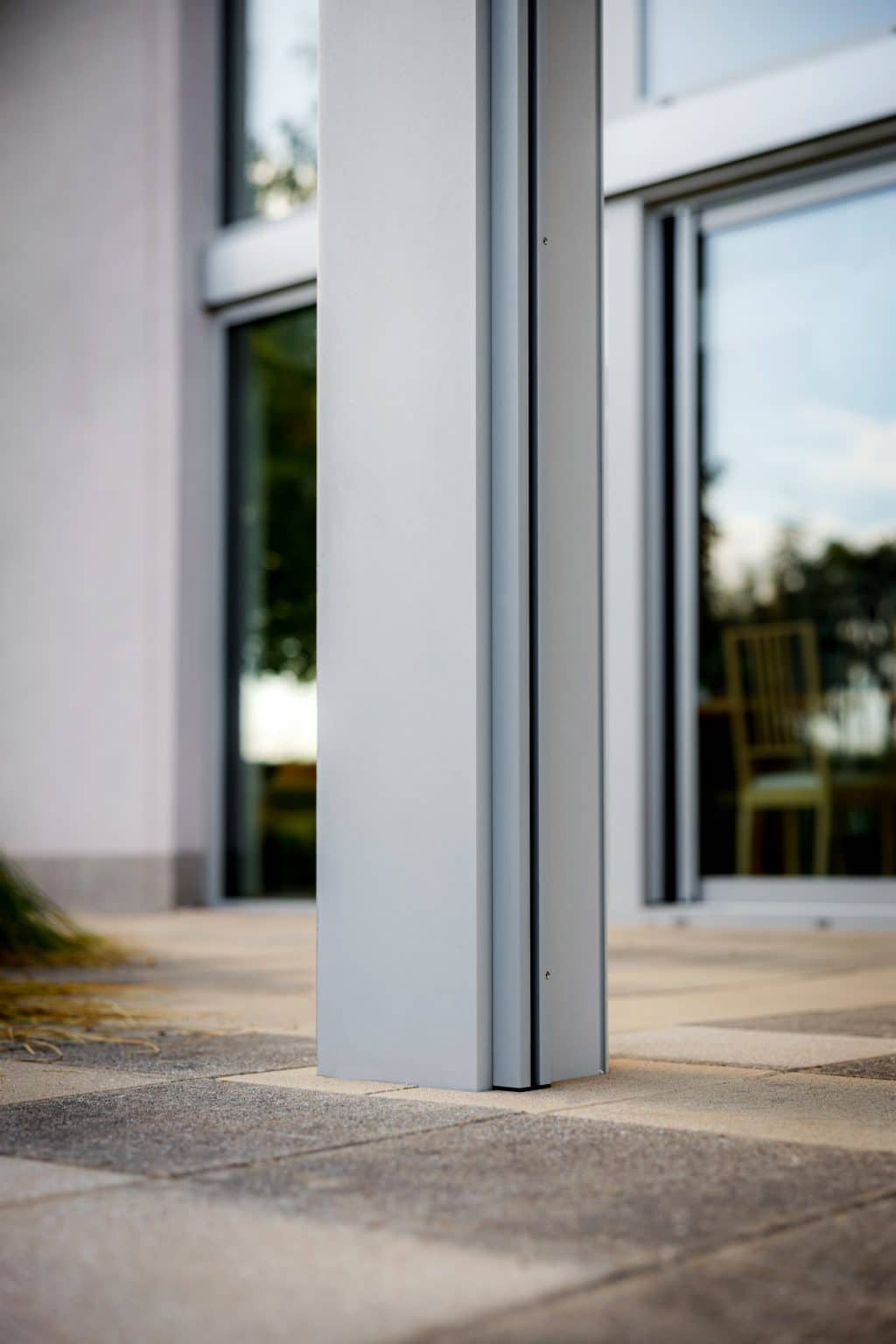 Detail sloupu pergoly LAMARK se skleněnou střechou | Stříbrná hliníková barva | Screenové rolety | Větrné čidlo | LED osvětlení