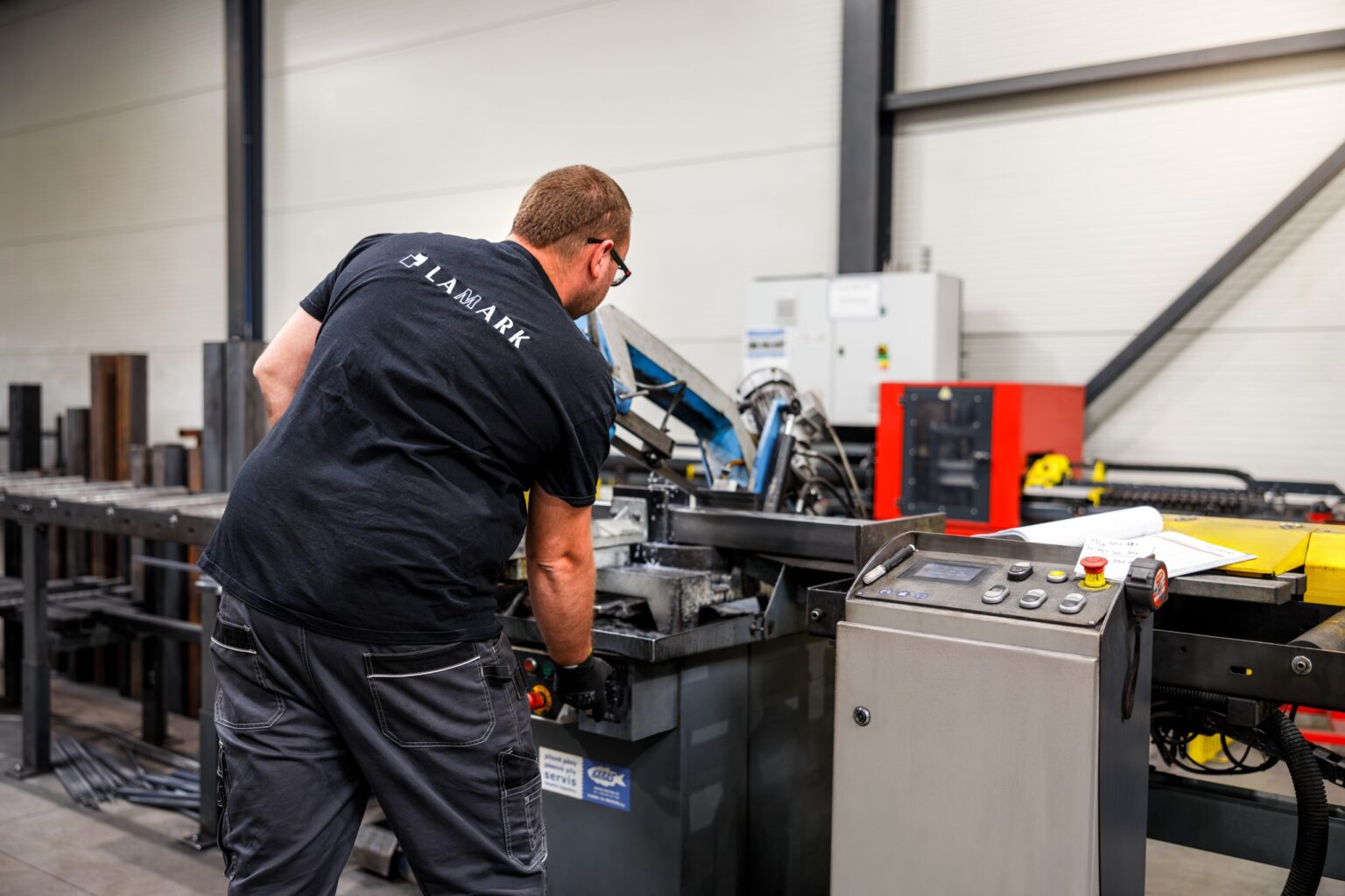Zaměstnanec LAMARK u pásové pily ve výrobní hale Nový Bydžov